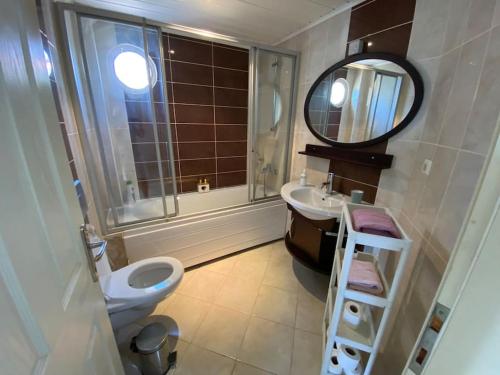 ベレキにあるSunset Apartmentsのバスルーム(洗面台、トイレ、鏡付)
