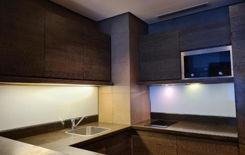 a kitchen with a sink and a microwave at Four Points by Sheraton Al Ain in Al Ain