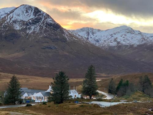 una montaña con una casa y árboles delante de ella en The Cluanie Inn, en Glenmoriston