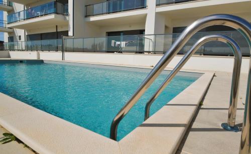 a swimming pool with a stairway leading to a building at Wave of happiness in São Martinho do Porto
