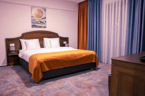 una habitación de hotel con cama y vestidor en una habitación en Hotel Aura Unirii en Alba Iulia