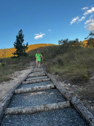 a woman walking up a set of stone stairs at Casa Verde na Chapada Diamantina in Palmeiras