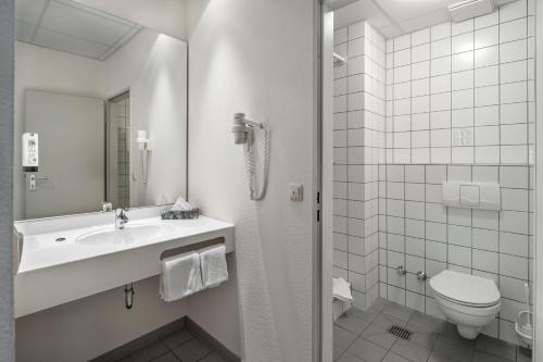 a white bathroom with a sink and a toilet at Center Hotel Kaiserhof in Naumburg