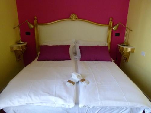 a bedroom with a white bed with purple walls at Appartamento Bel Sito in Bardolino