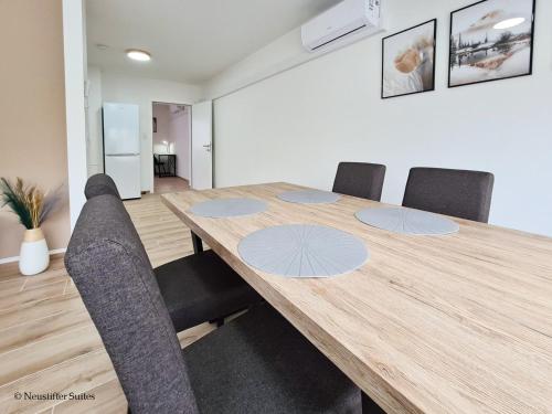 a dining room with a wooden table and chairs at St. Antoni Suite 5 in Eisenstadt