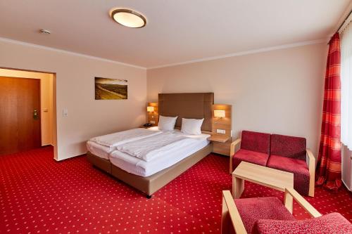 ein Hotelzimmer mit einem Bett und einem Stuhl in der Unterkunft Hotel Café Ernst in Bernkastel-Kues
