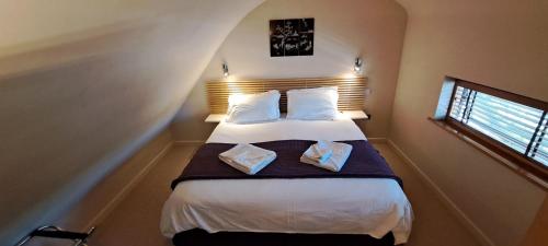 a bedroom with a bed with two pillows at South House in Winchester
