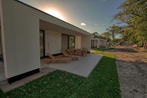 a building with a patio with chairs and tables at Najade Resort Het Gooi in Eemnes