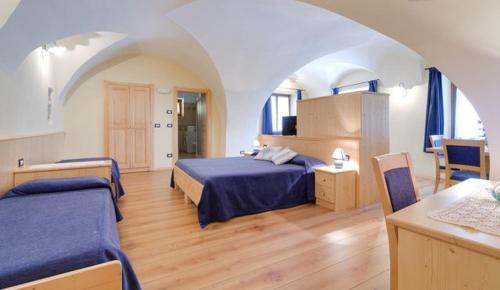 1 Schlafzimmer mit 2 Betten in einem Zimmer mit einem Bogen in der Unterkunft Agriturismo La Canonica in Brez