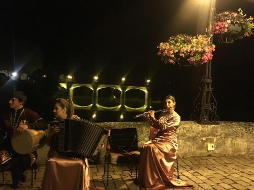 a group of people playing music on a street at night at L'ancienne Forge - a stylish medieval holiday home in Confolens