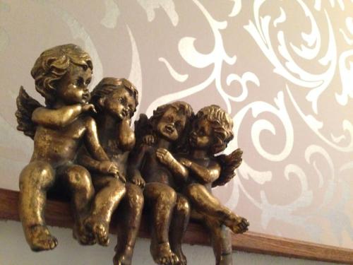 a bronze statue of three children sitting on a wall at L'ancienne Forge - a stylish medieval holiday home in Confolens