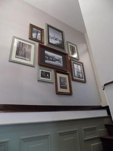 a bunch of pictures on a wall above a door at L'ancienne Forge - a stylish medieval holiday home in Confolens