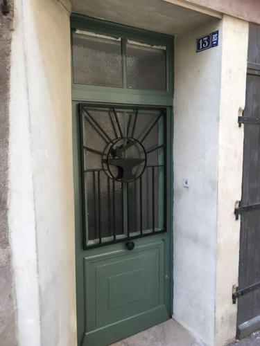a green door with a window on a building at L'ancienne Forge - a stylish medieval holiday home in Confolens