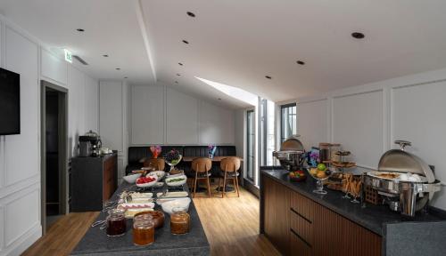 a kitchen with white cabinets and a black counter top at Livro Hotel in Istanbul