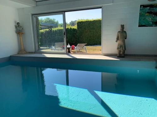 une personne debout à côté d'une piscine dans l'établissement Lovely 1-bedroom appartement Le Joyau with indoor pool and sauna, à Lasne
