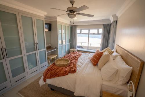 ein Schlafzimmer mit einem großen Bett und einem Fenster in der Unterkunft Deja Blue Beachfront Villa, Newly renovated in Langstrand