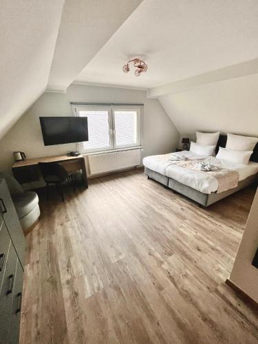 a bedroom with a bed and a desk and a television at Hotel Waldeslust in Kurort Altenberg