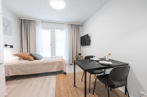 于韋斯屈萊的住宿－Forenom Serviced Apartments Jyväskylä Vaasankatu，一间卧室配有一张床和一张桌子及椅子