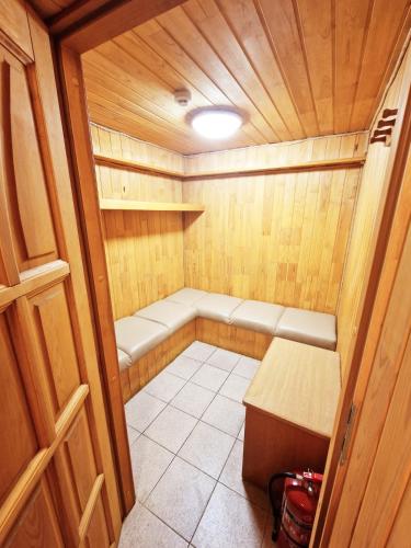 a small sauna with a bench and a table at KALIDA Rooms for rent in Raseiniai