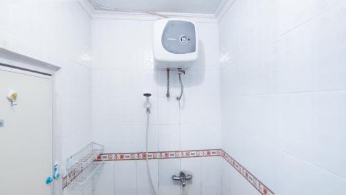 a white bathroom with a shower and a toilet at Kozii Room at Evenciio Apartment in Pondokcina