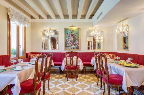 a dining room with two tables and red chairs at Canal Grande in Venice