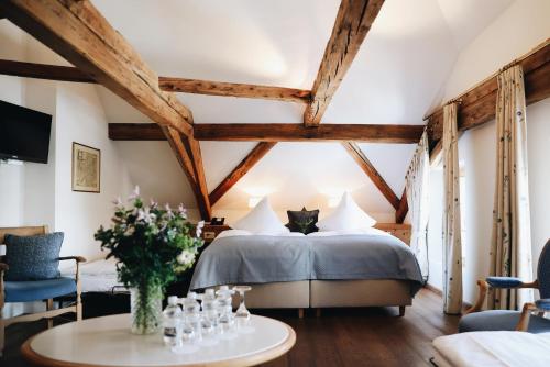 a bedroom with a bed with a cat sitting on it at Hotel Steinbock Pontresina in Pontresina