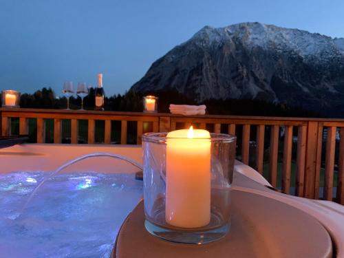 a candle sitting on a table next to a pool at Die Tauplitz Lodges - Penthouse Grimming D7-1 by AA Holiday Homes in Tauplitz