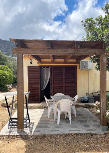 a patio with a table and chairs under a pergola at Donnigheddu in Rudalza