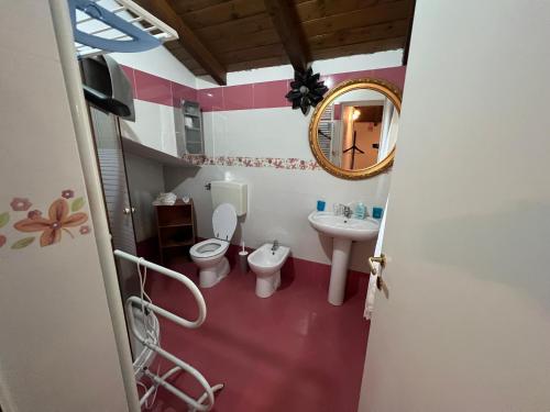 ein Badezimmer mit einem Waschbecken, einem WC und einem Spiegel in der Unterkunft Agriturismo e Az. Agricola Ma.Mi in Sale