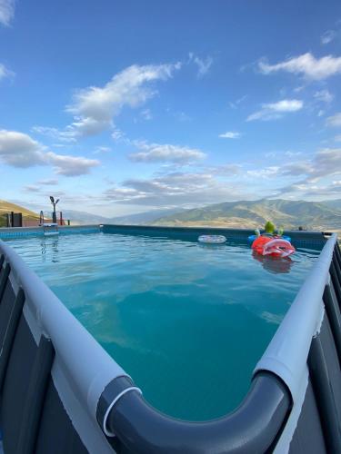 a swimming pool with blue water and mountains in the background at ANGINE Resort Hotel in Vanadzor