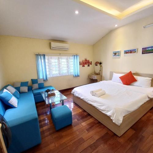 een slaapkamer met een groot bed en een bank bij Hanowood Homestay in Hanoi