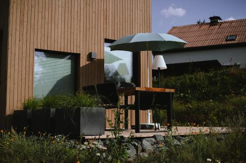 a chair and an umbrella on a patio at Wiesenglück Tiny House Hotel in Heilbad Heiligenstadt