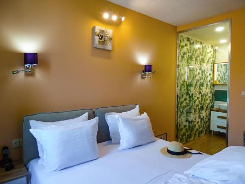 a bedroom with a bed with white pillows and a mirror at Art Hotel Simona in Sofia
