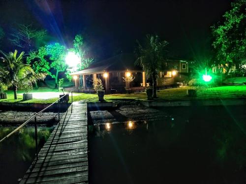 une maison avec piscine la nuit dans l'établissement Rancho a beira rio 2-bedroom cottage, à Juritis