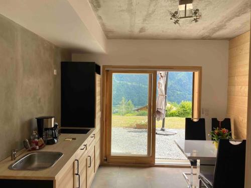 a kitchen with a sliding glass door to a patio at Gîte Au Balcon de Passy/Plaine Joux, classé 2 ** in Passy