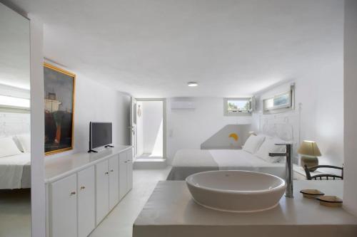 a white bedroom with a large white bowl on a table at Villa Aphrodite · Elegant villa, sea views, designer renovation in Ambelas