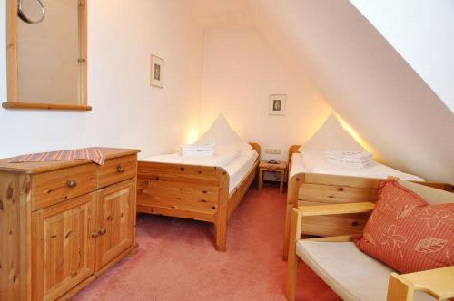 Zimmer mit 2 Betten und einer Bank im Dachgeschoss in der Unterkunft Sylter Finke Appartement in Wenningstedt-Braderup