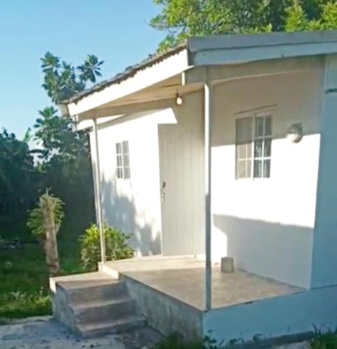 un pequeño edificio blanco con puerta y escaleras en Villa D'Vene, en Belle Air Summit