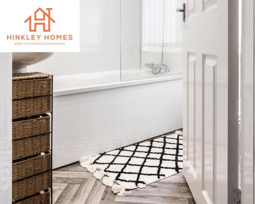 La salle de bains est pourvue d'une baignoire, d'un lavabo et d'un tapis. dans l'établissement Comfy 4bed Home - Free Parking, Wifi - Long Stays Welcome By Hinkley Homes Short Lets & Serviced Accommodation, à Litherland