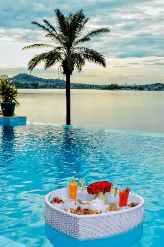 a tray of food in the water with a palm tree at Divine Resort & Spa in Kampala
