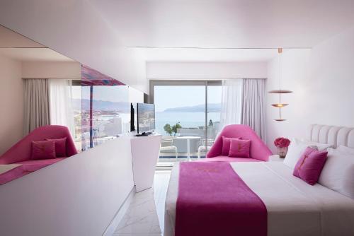 ein Hotelzimmer mit zwei Betten und einem Fernseher in der Unterkunft I Resort Beach Hotel & Spa in Stalida