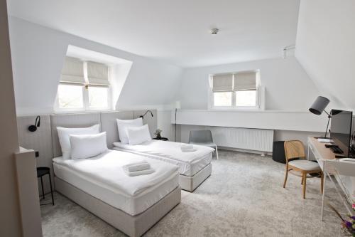 Biała sypialnia z 2 łóżkami i biurkiem w obiekcie Port Sołacz w Poznaniu