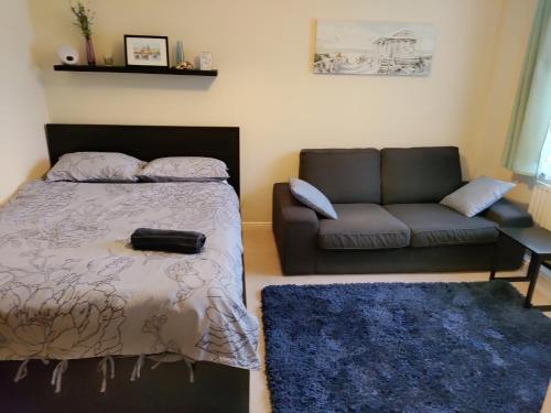 a bedroom with a bed and a couch at Double Room in a Top Floor Shared Apartment in Northampton