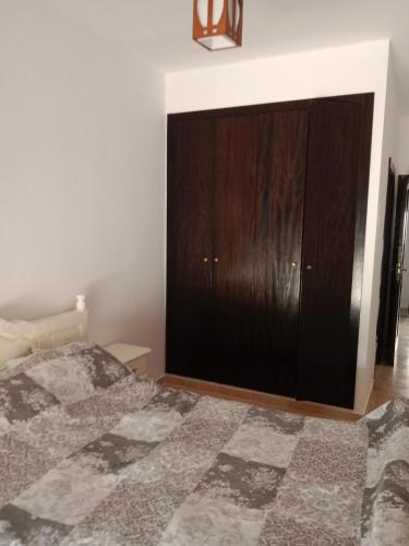 a bedroom with a bed and a wooden cabinet at Marina Bahia in Saïdia