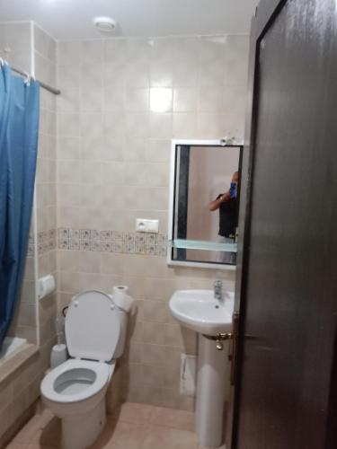 a person taking a picture of a bathroom with a toilet and sink at Marina Bahia in Saïdia