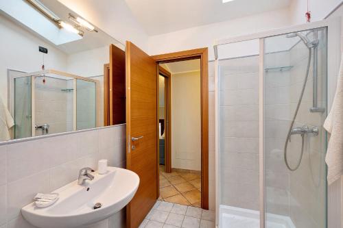 a bathroom with a sink and a glass shower at Ultimo Tiro-appartamento Terzo Tiro in Cisano sul Neva