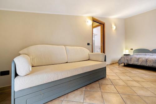 Ultimo Tiro-appartamento Terzo Tiro في Cisano sul Neva: كنب جالس في غرفة بسرير