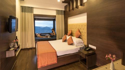 un dormitorio con una cama y una ventana con una mujer en una bañera en Koti Resort, en Shimla