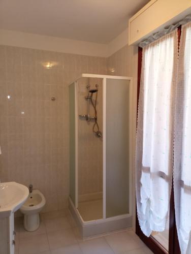 a bathroom with a shower and a toilet and a sink at Appartamento La Libellula in Grosseto