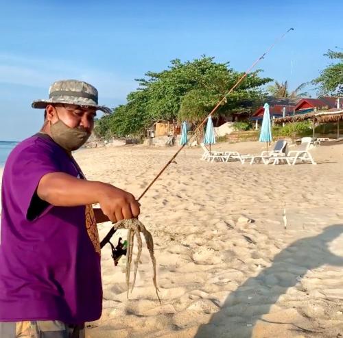a man is holding a string on the beach at Lamai chalet in Amphoe Koh Samui